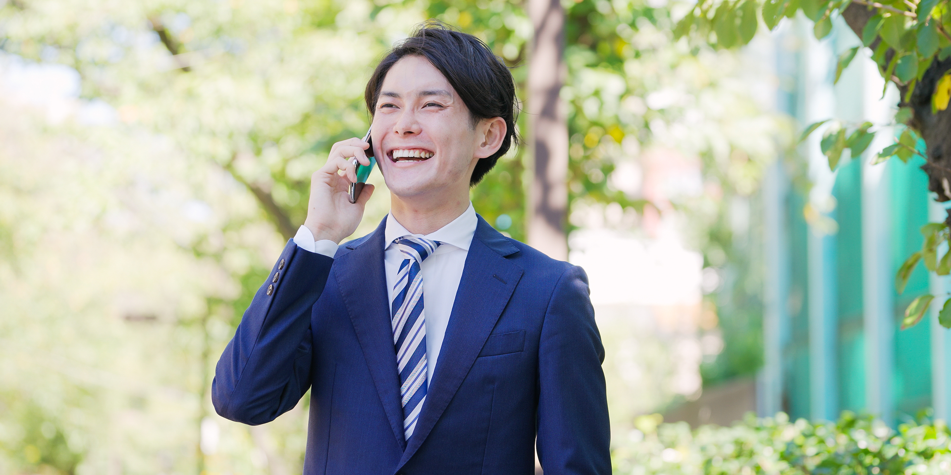 電話を掛けるスーツの男性